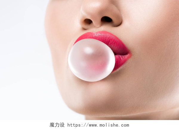 一个美丽的女子在吹泡泡糖妇女的修剪的看法与口香糖泡沫, 被隔绝在白色
